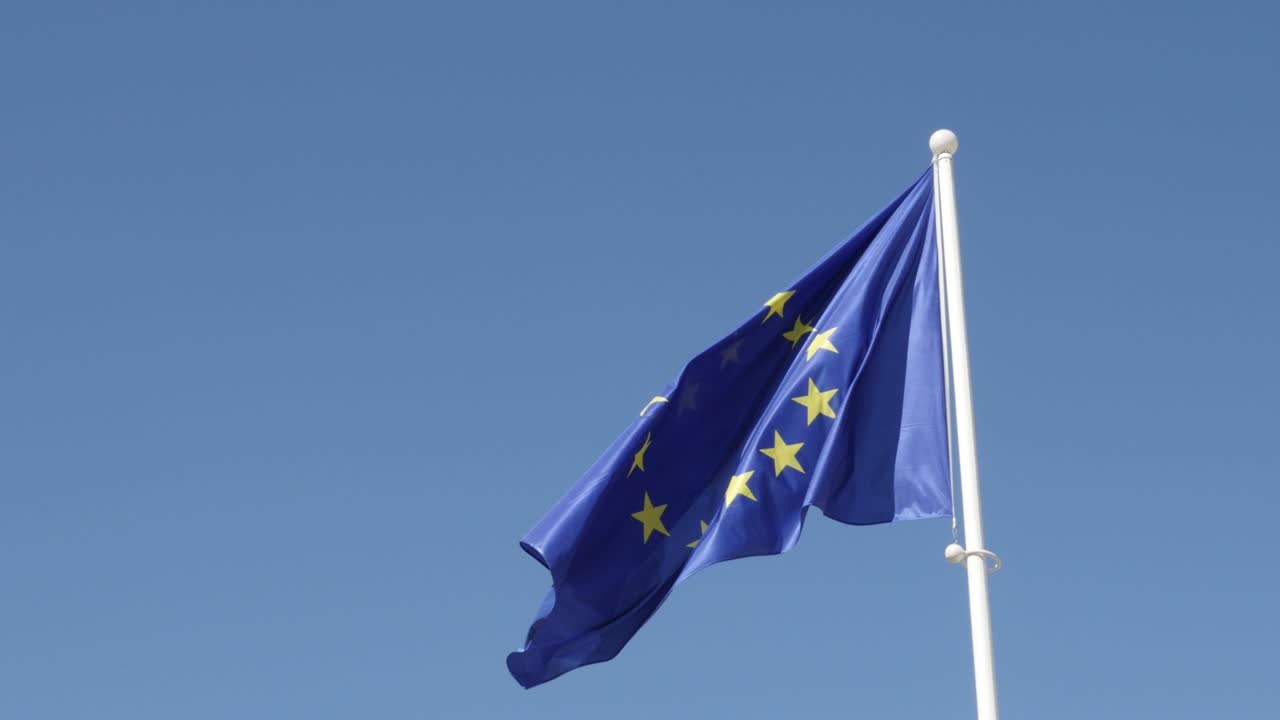 se levantó en el mástil de la bandera blanca la bandera de la unión europea ondeando en el viento