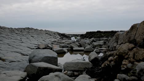 Stone-beach-in-South-of-England,-surrounded-by-cliffs