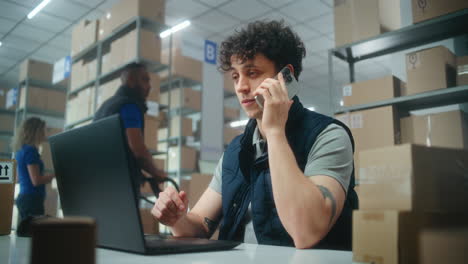 trabajador de almacén en teléfono y portátil