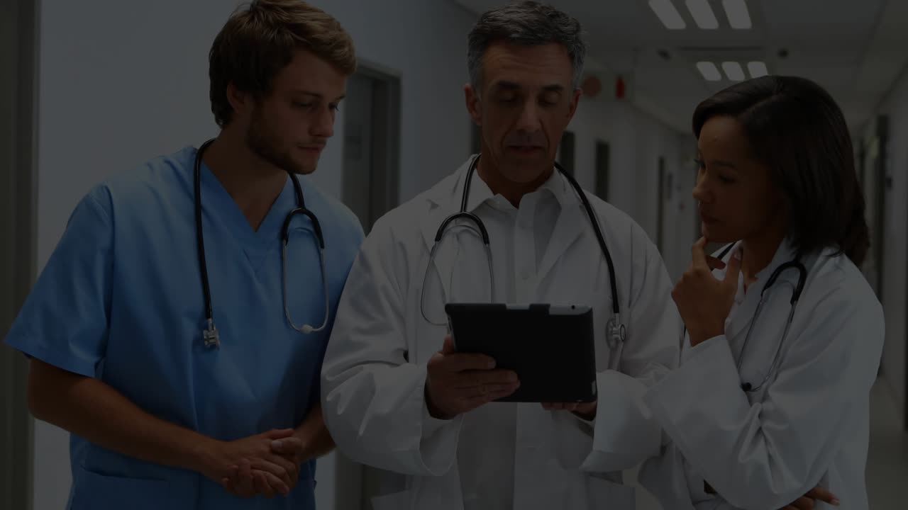 Equipe medica che si china verso un tablet indicando dati paziente in tempo reale con grafici fluttuanti e pulsanti.