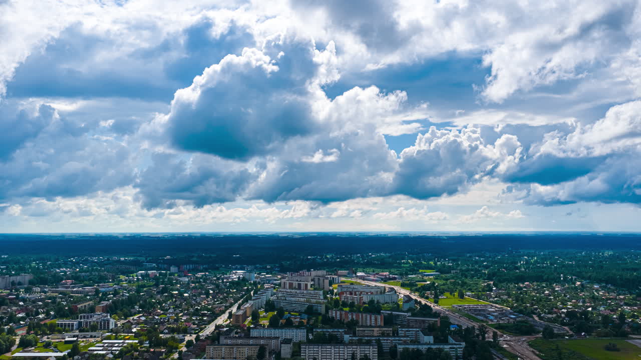 Drone hyperlapse of city beneath dramatic clouds and blue sky
