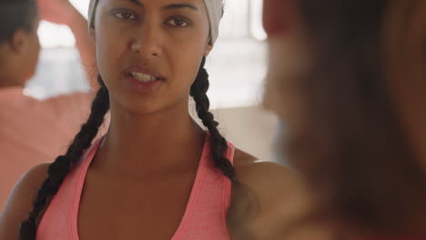 portrait sporty young hispanic woman chatting to friend in dance class discussing healthy fitness lifestyle sharing training tips enjoying conversation in studio