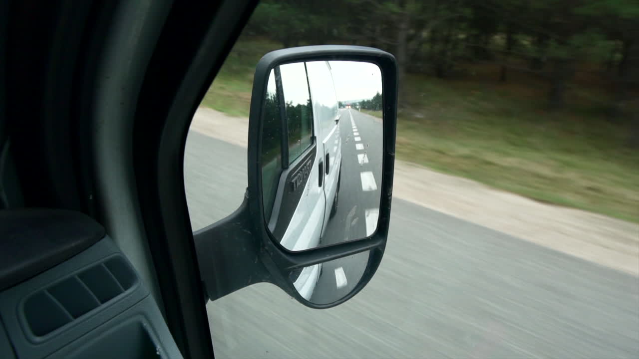 mirando el espejo del coche en movimiento en la calle