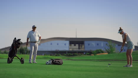 business couple play golf on course. two golfers practicing in country club.