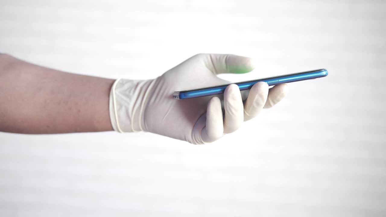mano con guantes sosteniendo un teléfono inteligente