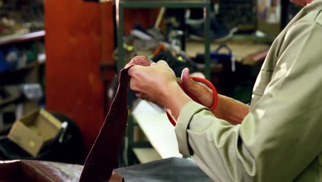 cobbler cutting a piece of leather