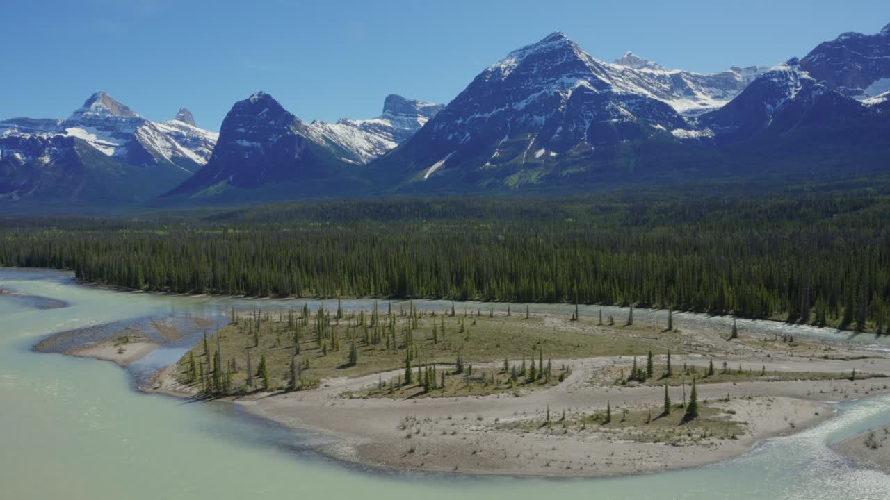 Athabasca-floden, der slynger sig gennem skove med snedækkede Rocky Mountains i Jasper Nationalpark, Canada