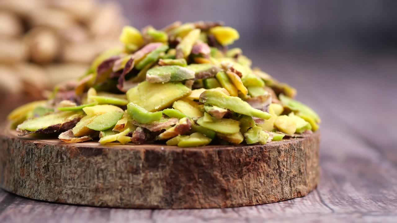Mucchio di pistacchi tritati su tagliere di legno