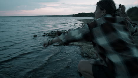 Woman-Throwing-Pebbles-into-Lake