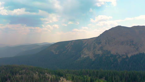 Aerial-Drone-Footage-of-Nederland-Colorado-Mountains-Covered-in-Thick-Pine-Tree-Forest-with-Clouds-Casting-Shadows-during-Summer-in-the-Rocky-Mountains