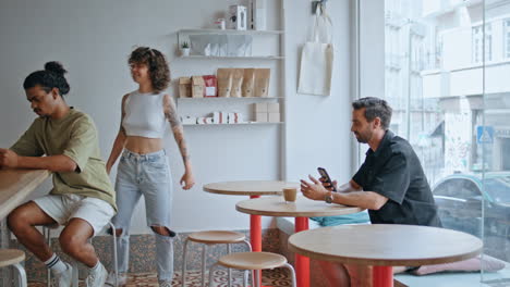 camarera de café sirviendo al cliente hombre sentado en la mesa. chica trayendo una taza de café