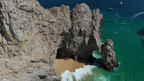 toma cinemática de drones de el arco y luego revelando los acantilados marinos y los barcos en cabo san lucas méxico