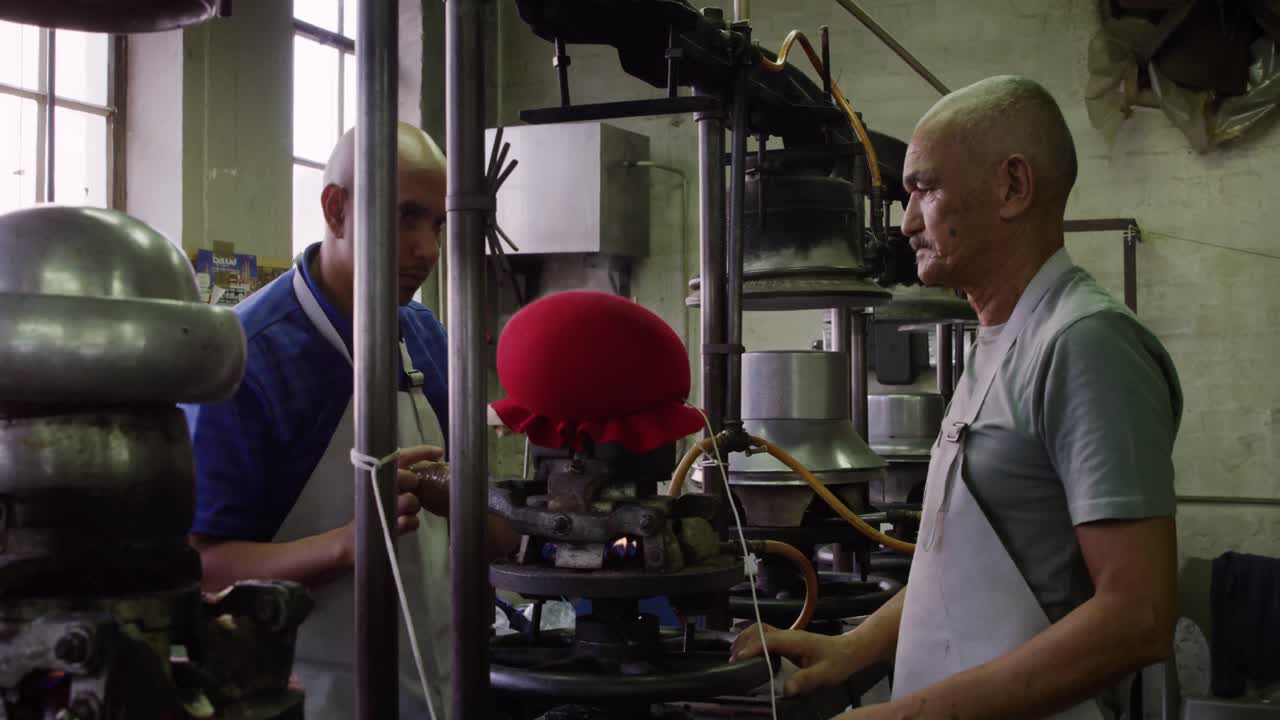 Mixed race men working at a hat factory