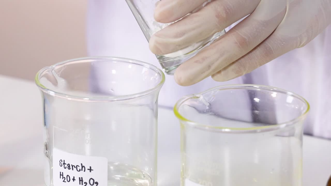 A demonstration of mixing solutions in labeled beakers using laboratory equipment.