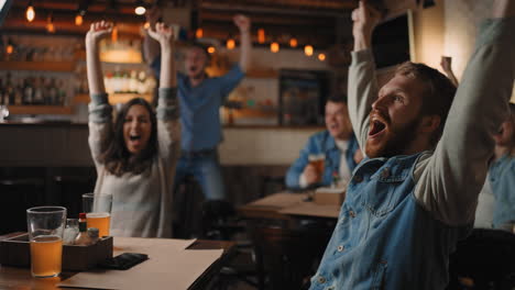 friends and fans rejoice together emotionally watching football on tv in a bar and celebrating the victory of their team after scoring a goal at the world cup. hockey. the scored puck. fans in the pub