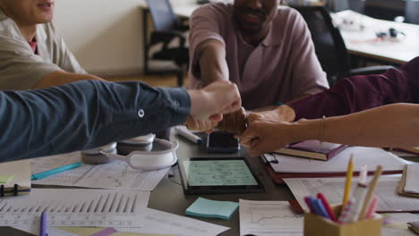 diverse business team celebrates success with a fist bump in an office meeting