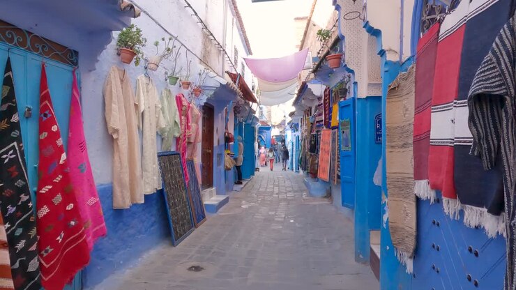 Panoramica della Medina di Chefchaouen, strada stretta blu e negozi locali, Marocco.