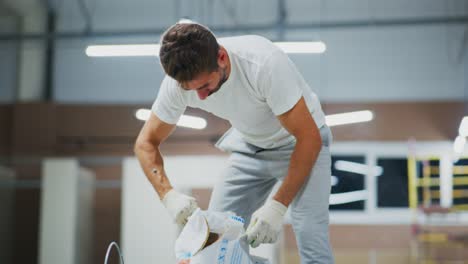 dedicated worker engaged in manual labor carefully mixing materials on a construction site, showcasing commitment and attention to detail in his task