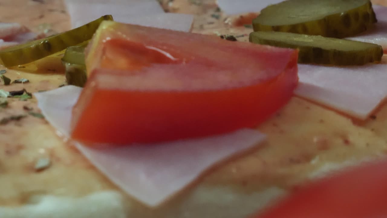pizza sin cocinar con jamón y pepinillos