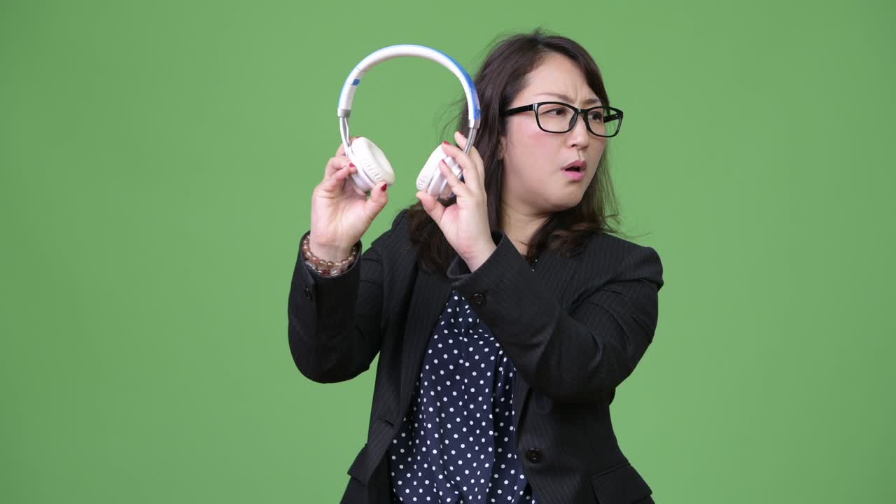 una hermosa mujer de negocios asiática madura escuchando música
