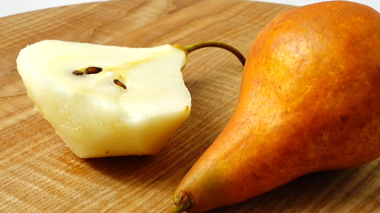 Pere su un tagliere di legno in cucina. Ripresa in movimento
