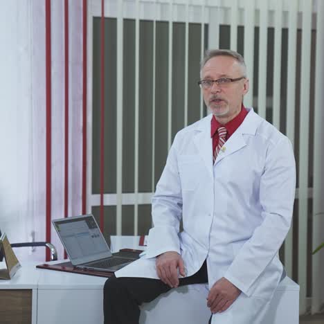 medical consultation. professional man doctor wears medical uniform talking on camera in the modern cabinet in clinic