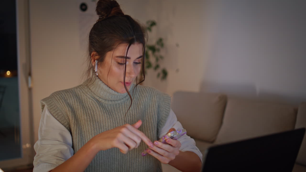 Videocalling woman checking content on smartphone at late workplace closeup