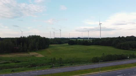 Autos-Fahren-Auf-Der-Autobahn-Mit-Windkraftpark-Im-Hintergrund