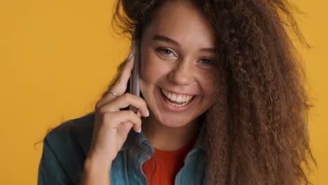 caucasian curly haired woman calling on smartphone.