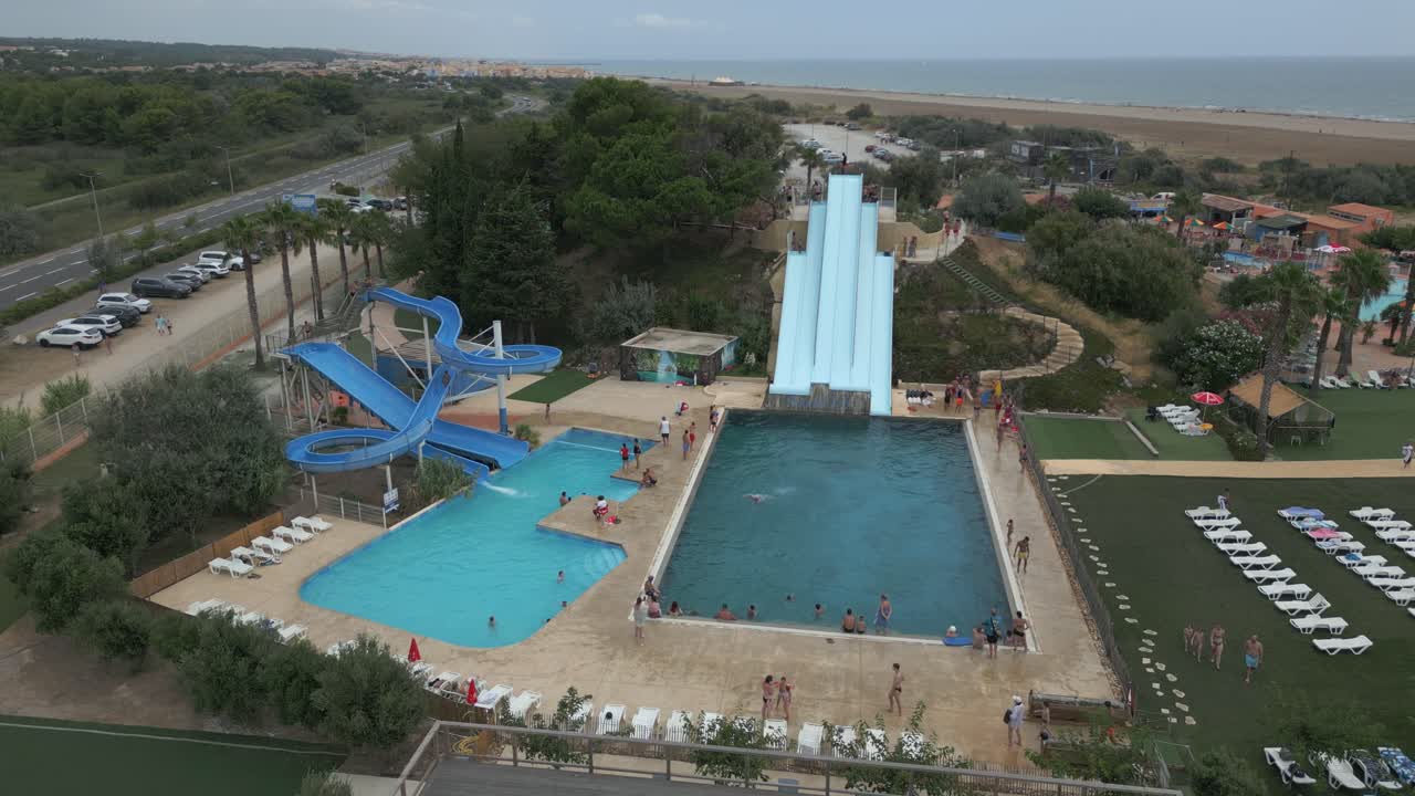 Aerial View of a Water Park with People Enjoying Water Slides and Pools