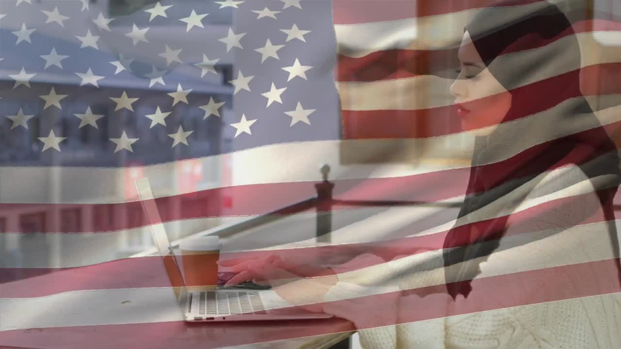 анимация американского флага, развевающегося над женщиной в хиджабе с помощью ноутбука на заднем плане