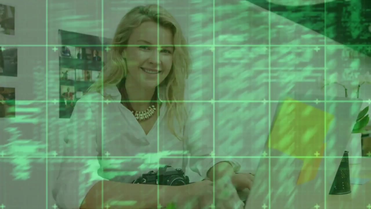 Woman placing hands typing on yellow PC glancing smiling working in tech green grid filling frame