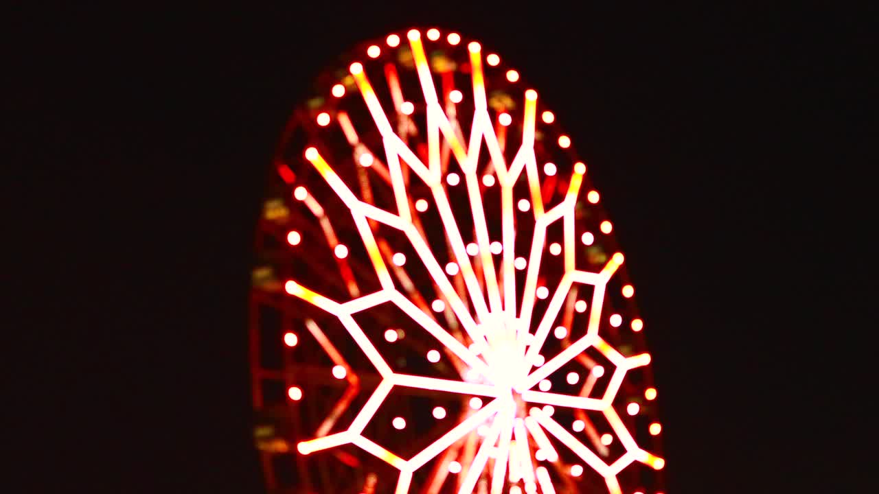 video sfocato sfocato di una ruota panoramica illuminata che gira di notte