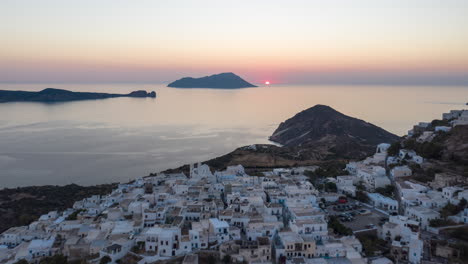 Hyper-Lapse-Aéreo-Moviendo-El-Lapso-De-Tiempo-Sobre-El-Típico-Pueblo-Griego-Al-Atardecer-En-Milos,-Isla-De-Grecia-Con-Vista-Al-Mar