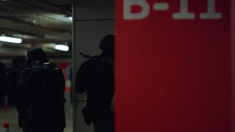 soldiers hiding behind wall at operation. swat police officers storming building