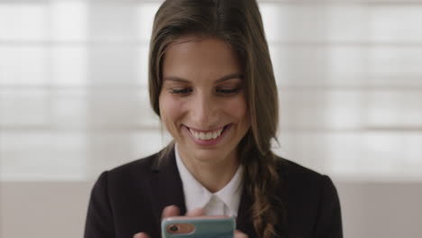 Primer-Plano-Retrato-De-Una-Joven-Mujer-De-Negocios-Caucásica-Pasante-Enviando-Mensajes-De-Texto-Navegando-En-Las-Redes-Sociales-En-Línea-Usando-Un-Teléfono-Inteligente-Sonriendo-Disfrutando-De-La-Comunicación-Móvil