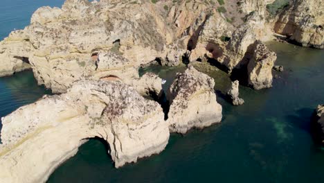 Sobrevuelo-De-Kayaks-Y-Botes-En-Grutas-Del-Algarve-Acantilados-De-Color-Amarillo-Dorado