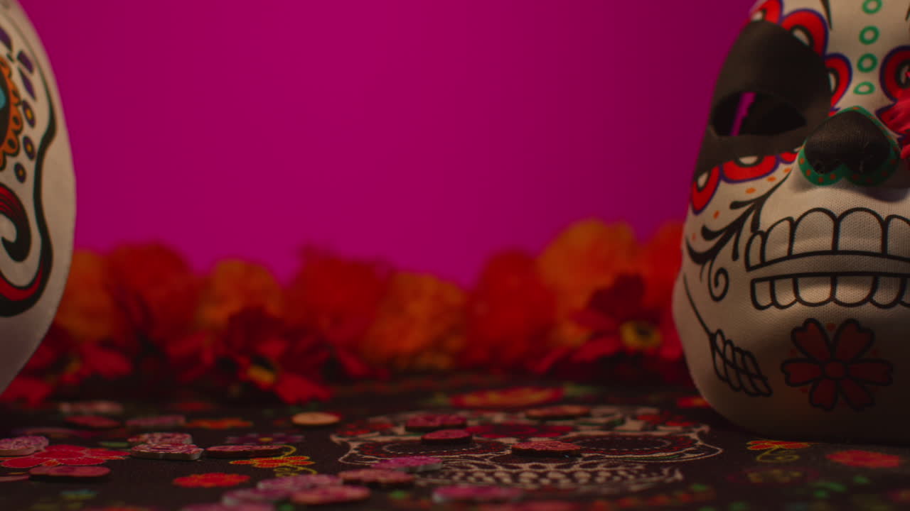 vida muerta de máscaras de cráneo decoradas con flores celebrando la fiesta mexicana de dia de muertos o día de los muertos contra un fondo oscuro