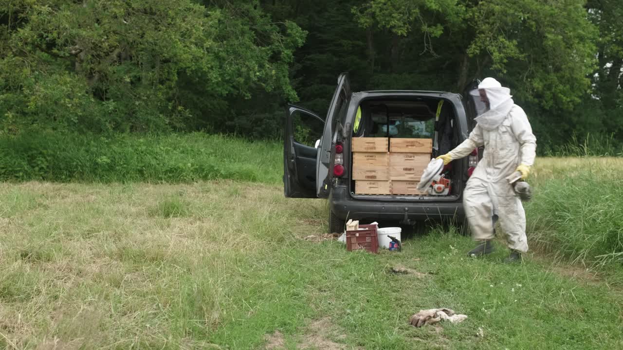 Clip of experienced positive beekeeper with smoke hive tool in the farm garden. Apiarist. Apiculture. Professional. Beekeeping business.