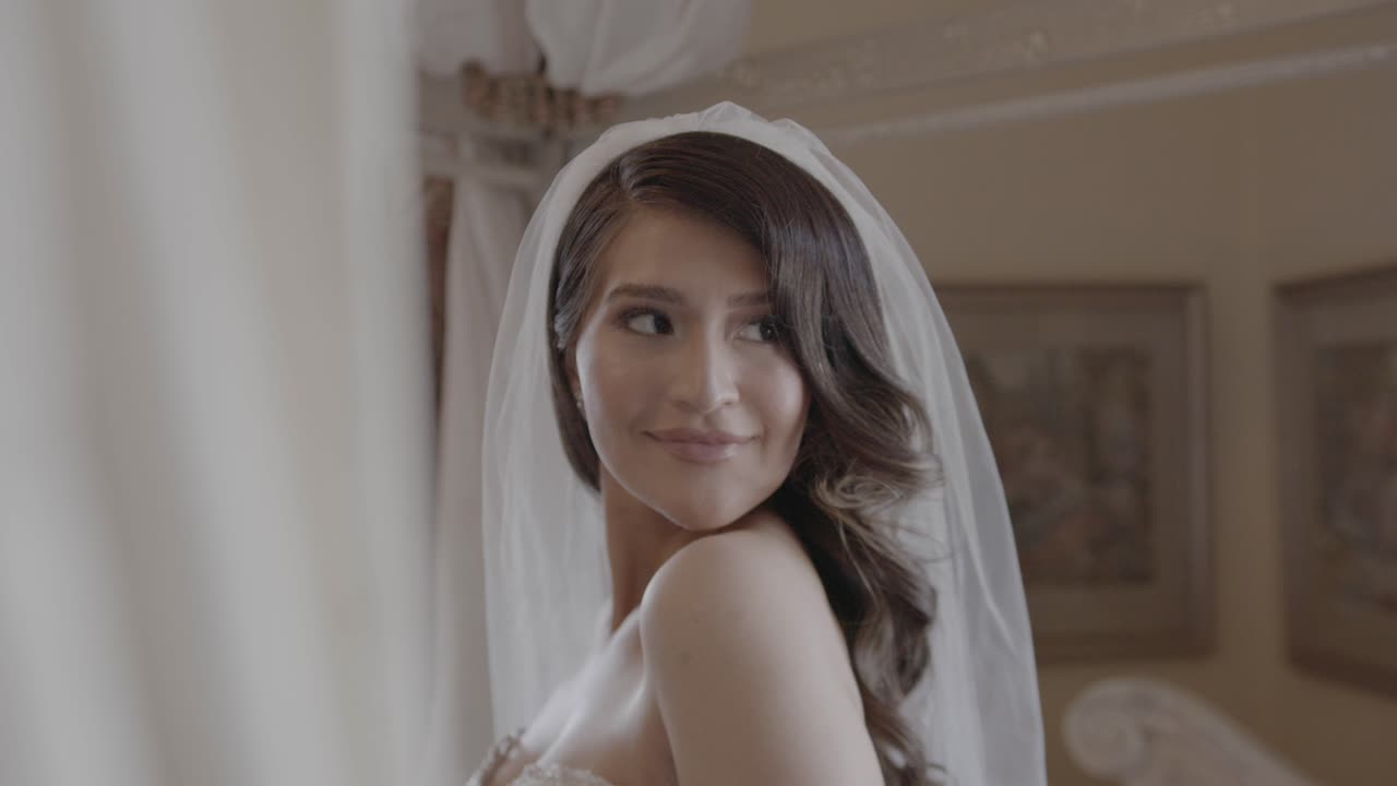 Scatto spontaneo di una sposa felice che sorride e guarda indietro.