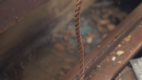 Man-gathers-scrap-wood,-FOCUS-ON-ROPE