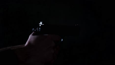 slide of 9mm handgun chambering a bullet and shooting multiple times in a dark room