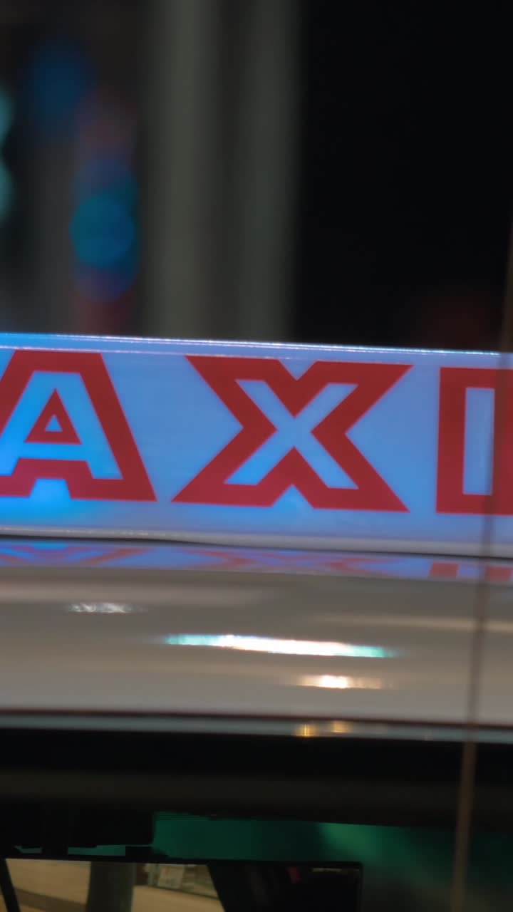 Letrero de taxi iluminado en el techo de un coche en la noche urbana