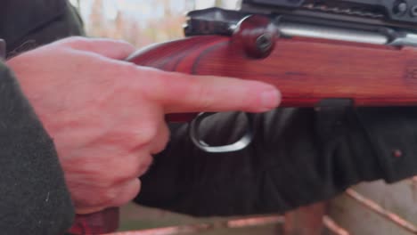 close-up, the hand of a hunter loads a hunting rifle