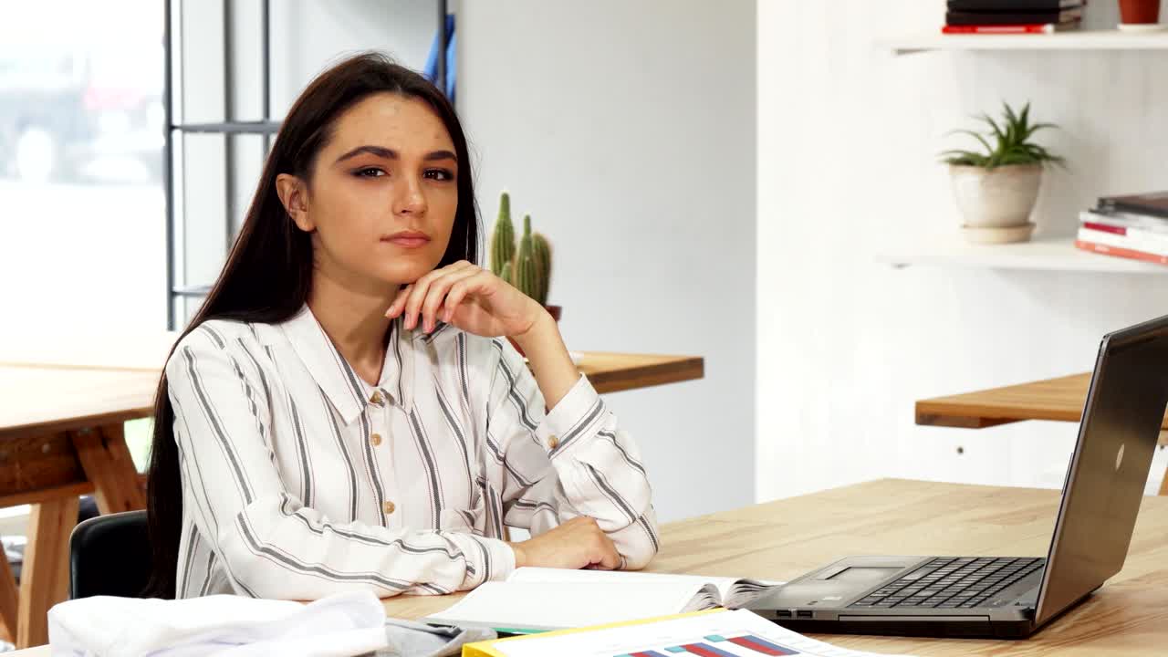 joven mujer de negocios mirando pensativa a la cámara