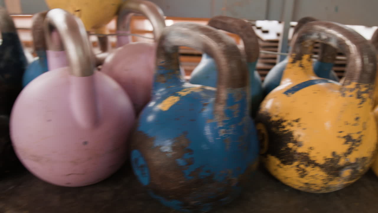 A person interacting with a collection of vintage kettlebells