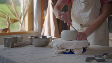 woman shaping a clay bowl