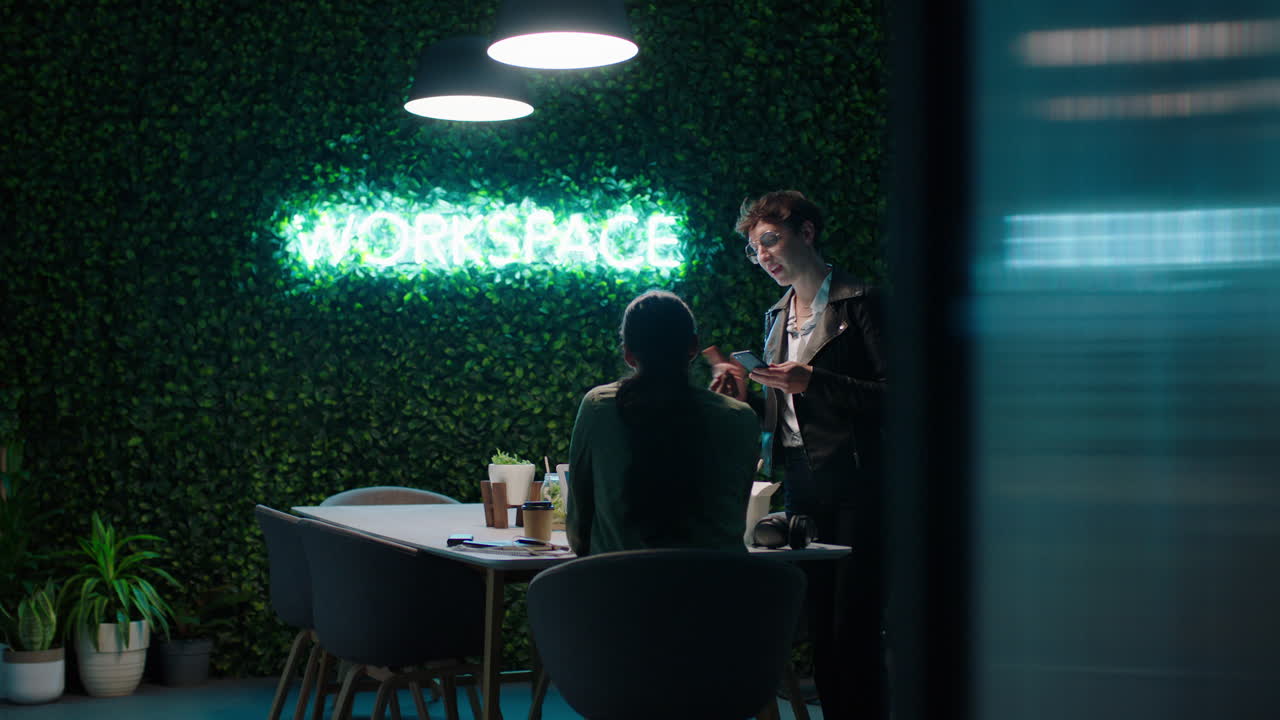 늦게 일하는 젊은 사업가 동료들이 창의적인 아이디어를 모으고 프로젝트 마감일을 논의하고 협력하여 트렌디한 스타트업 사무실 작업 공간에서 성공적인 전략을 계획합니다.