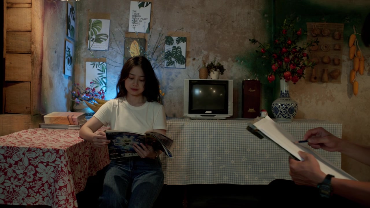 sliding view into a man drawing a young woman seated at a table reading