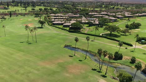 Aerial-fly-over-reveal-of-Kaanapali-golf-course-and-the-west-Maui-mountains,-Hawaii